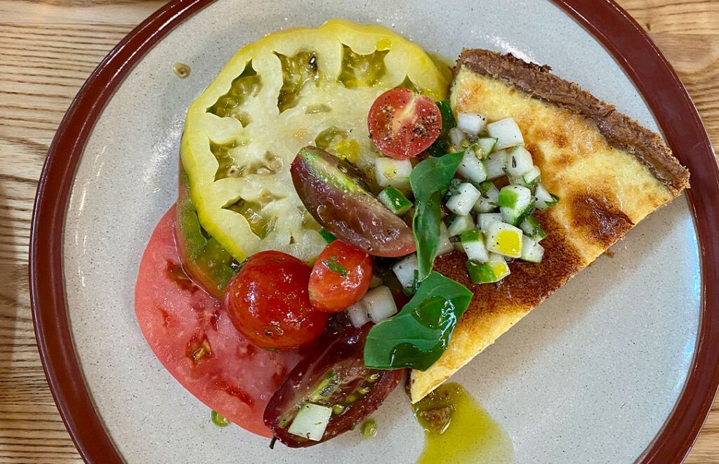 Chef Brandon Frederick's wood-fired kitchen, sourdough with smoked butter and farm-fresh pickled vegetables, and the most delicious truffle cheddar quiche with heirloom tomatoes – a road trip treat. | Courtesy of the author