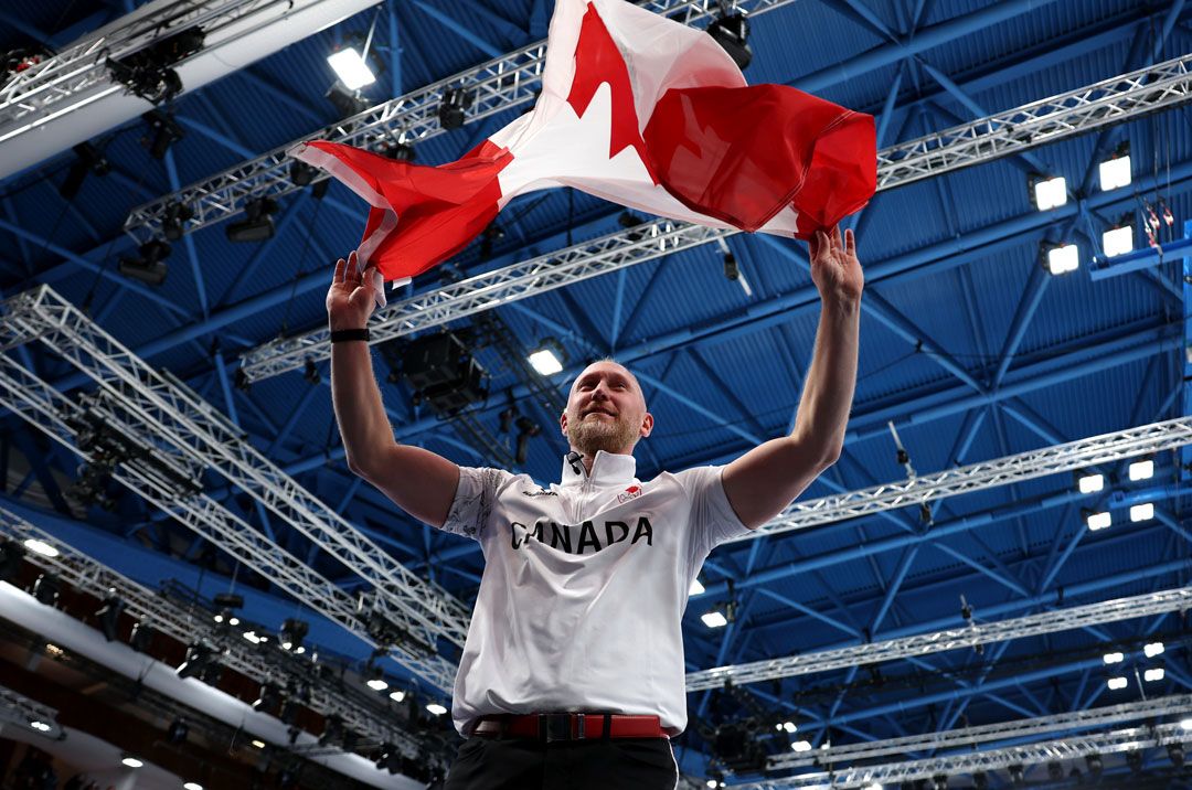 Men's curling gold medallist Brad Jacobs waves the flag after defeating Great Britain. | Mattia Ozbot/Getty Images